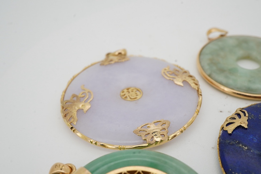 A collection of Chinese jewels, including three disc shaped pendants in pale lavender and green jadeite, mounted in gold, longest 4.6cm including bail; another disc-shaped pendant in lapis lazuli, mounted in gold; and a